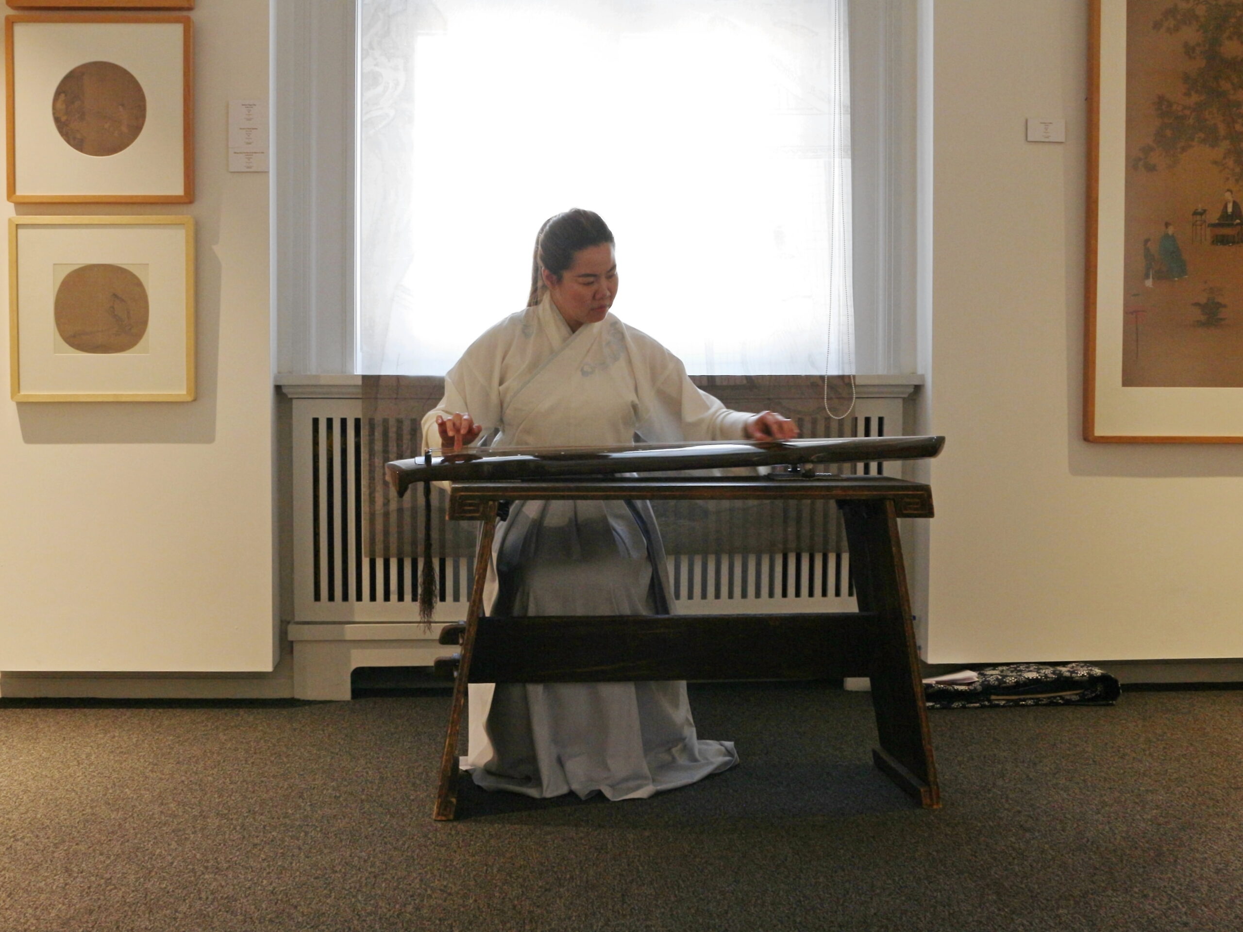 A musician in Hanfu playing the guqin
