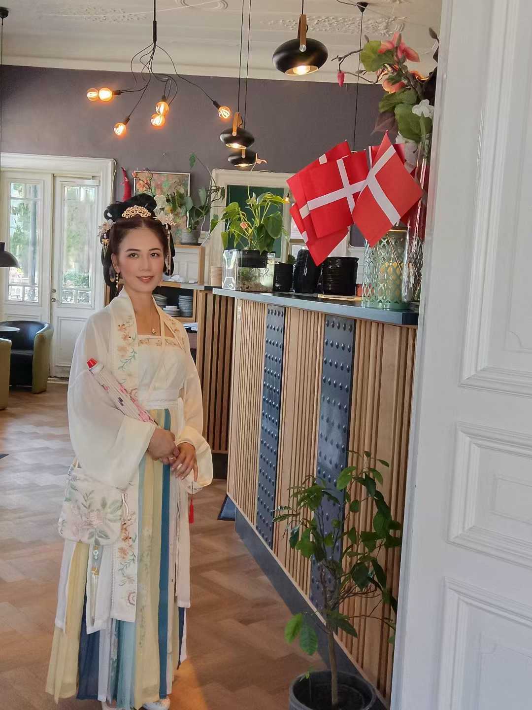 A member wearing Hanfu beside Danish flags